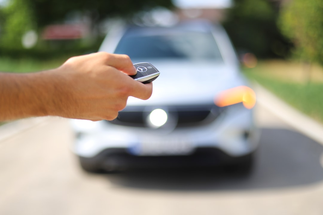 Hand holding car keys at a valet stand